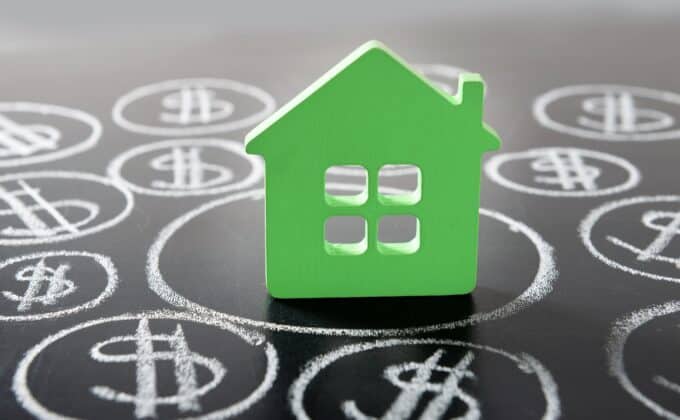 House figure and painted dollar symbols on chalkboard